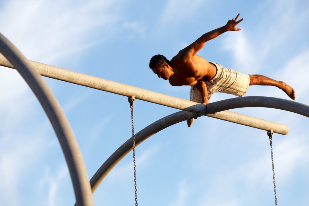 Eddie performing a one arm elbow lever on top of the Santa Monica rings!